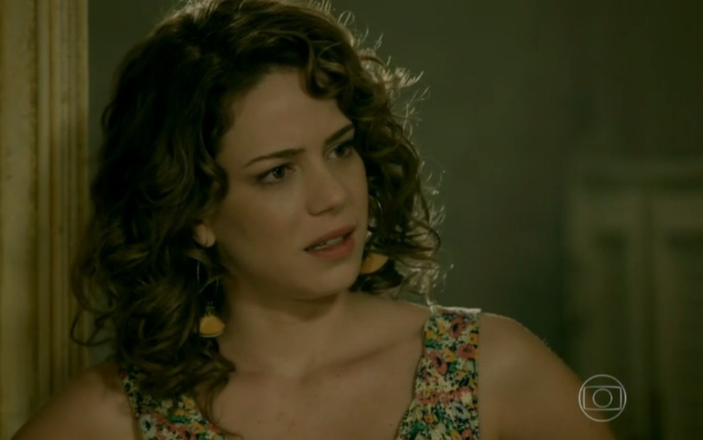 A atriz Leandra Lela, com uma blusa regata florida e expressão de surpresa, grava cena como Cristina de Império, novela das nove