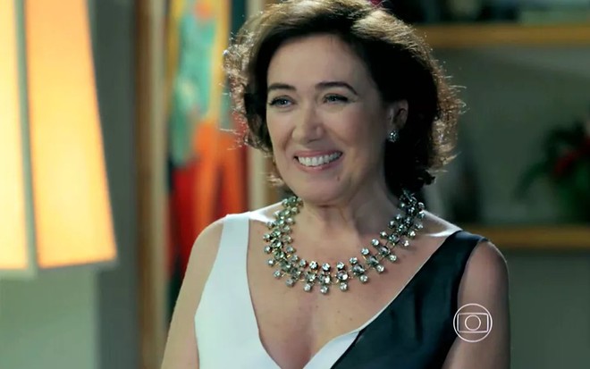A atriz Lilia Cabral, com um enorme sorriso no rosto, em cena como Maria Marta em Império