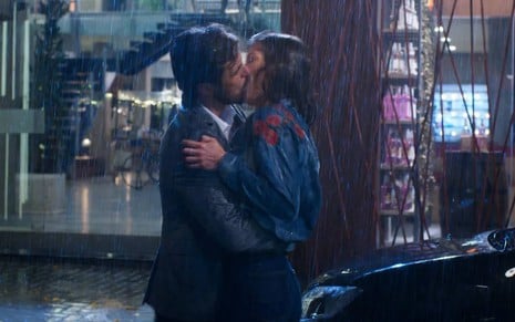 Rafael (Bruno Ferrari) e Kyra (Vitória Strada) se beijam na chuva em cena de Salve-se Quem Puder