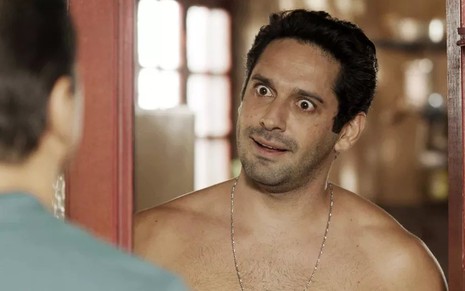 O ator João Baldasserini, sem camisa, com expressão de surpresa em cena como Zezinho em Salve-se Quem Puder