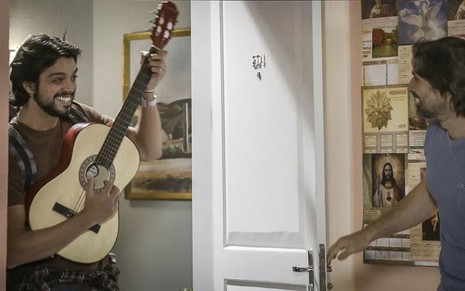 O ator Rodrigo Simas, com um violão, e o ator Murilo Rosa, segurando a porta, em cena como Alejandro e Mário em Salve-se Quem Puder