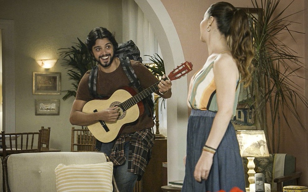 O ator Rodrigo Simas contracena com Nina Frosi em Salve-se Quem Puder; ele segura vilão e carrega mochila