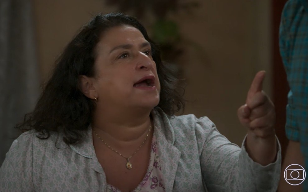 Grace Gianoukas grava de camisola e expressão séria apontando dedo para alguém fora de quadro em Salve-se Quem Puder, novela da Globo