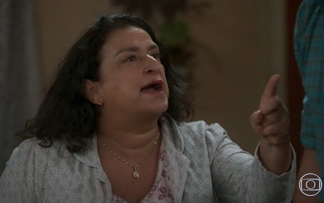 Grace Gianoukas grava de camisola e expressão séria apontando dedo para alguém fora de quadro em Salve-se Quem Puder, novela da Globo