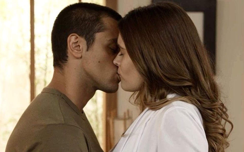 Os atores Felipe Simas e Juliana Paiva se beijam em cena de Salve-se Quem Puder; eles estão caracterizados como seus personagens, Téo e Luna/Fiona