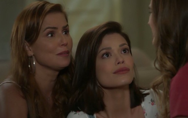 A atriz Deborah Secco se apoia na colega Vitória Strada durante cena em que as duas conversam com Juliana Paiva na novela Salve-se Quem Puder