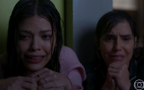 As mocinhas Kyra (Vitória Strada) e Alexia (Deborah Secco) molhadas com cara de sofrimento em cena de Salve-se Quem Puder