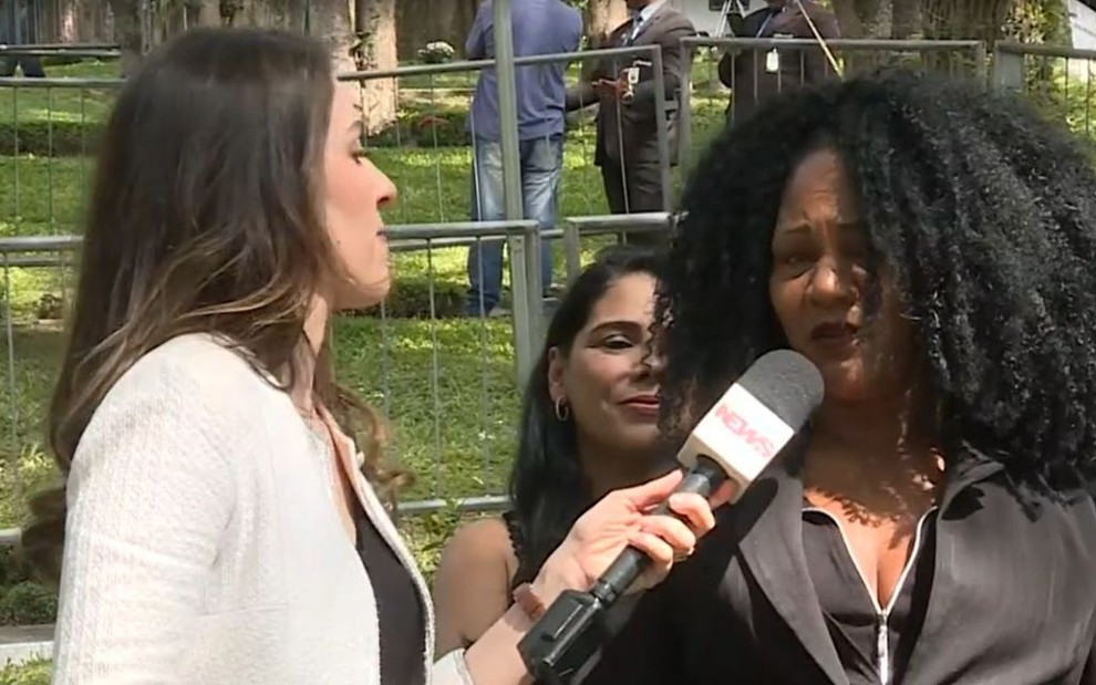 A repórter Gabriela Lian entrevista Ivone Pereira no enterro de Gugu