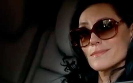 De óculos escuros e cabelo preto, Christiane Torloni está caracterizada como Tereza Cristina em cena de Fina Estampa