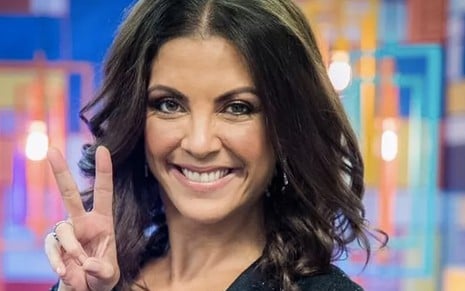 A apresentadora e escritora Thalita Rebouças faz a letra V com os dedos no cenário do The Voice Kids
