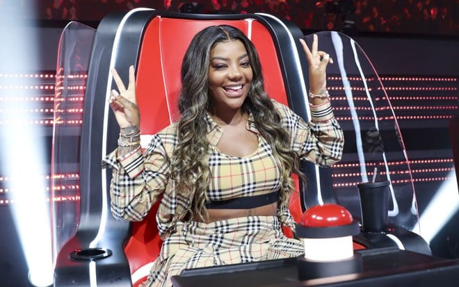 Ludmilla sorridente na cadeira de técnica do The Voice+, da Globo