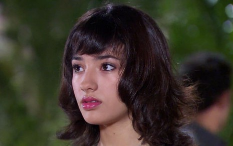 Carolina Oliveira em cena de Ti Ti Ti, caracterizada como Gabi; atriz olha com surpresa para alguém fora do quadro