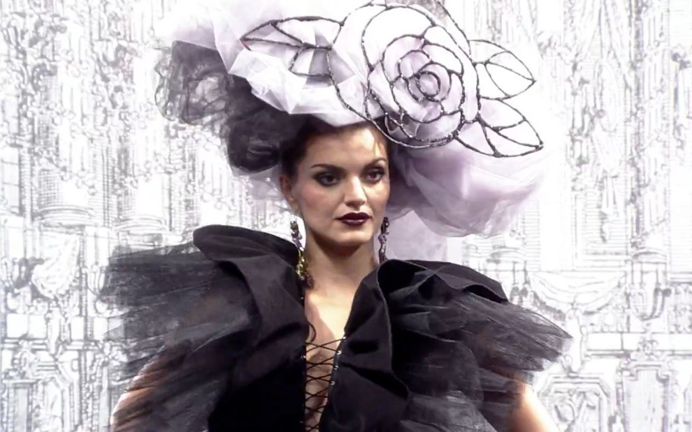 Mayana Neiva em cena de Ti Ti Ti; caracterizada com Desirée, atriz está com vestido preto e adorno na cabeça