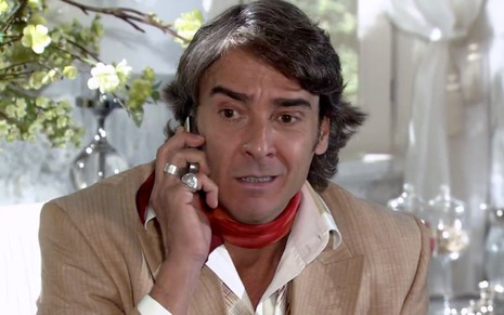 Alexandre Borges em cena de Ti Ti TI: caracterizado como Jacques Leclair, ator atende celular e tem feição preocupada