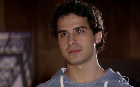 André Arteche em cena de Ti Ti Ti: caracterizado como Julinho, ator olha de maneira tensa para alguém fora do quadro