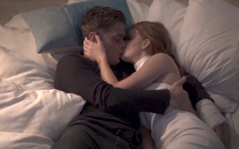 Arthur (Fabio Assunção) e Eliza (Marina Ruy Barbosa) se beijam deitados em travesseiros em cena de Totalmente Demais