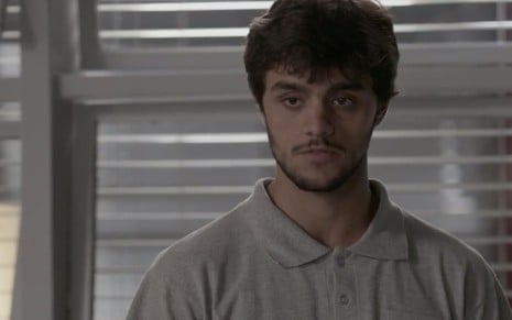 O ator Felipe Simas, vestindo uma camisa polo, tem expressão neutra em cena de Totalmente Demais