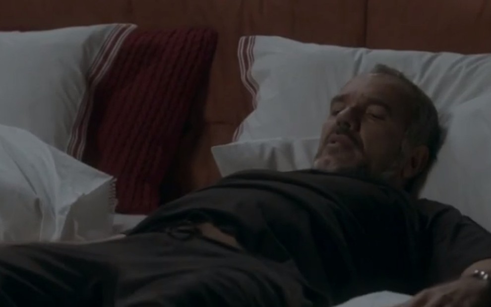 O ator Humberto Martins, deitado em uma cama, em cena como Germano na novela Totalmente Demais