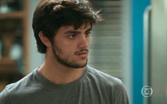 O ator Felipe Simas olha com expressão de surpresa para alguém fora de quadro em cena da novela Totalmente Demais