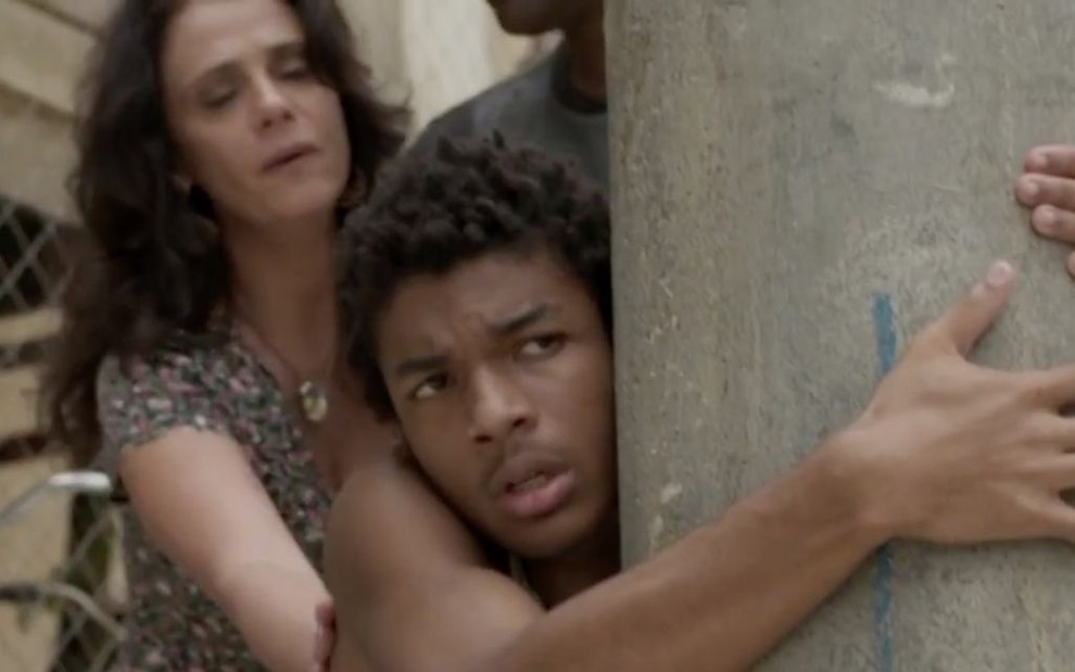 O ator Juan Paiva como o personagem Wesley se agarrando a um poste en cena da novela Totalmente Demais, da Globo