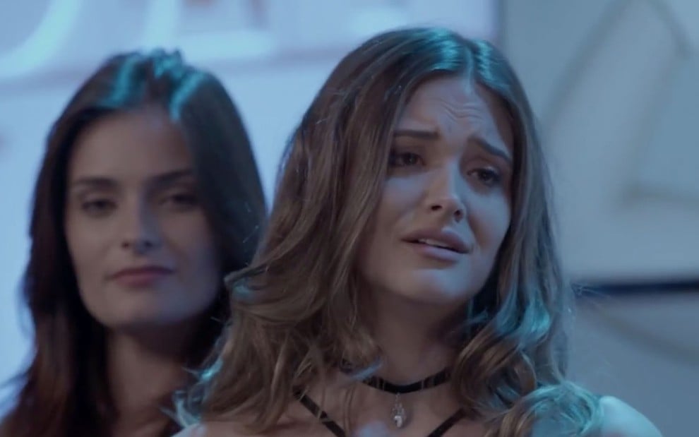 A atriz Juliana Paiva, com uma expressão de tristeza, caracterizada como a Cassandra em cena de Totalmente Demais