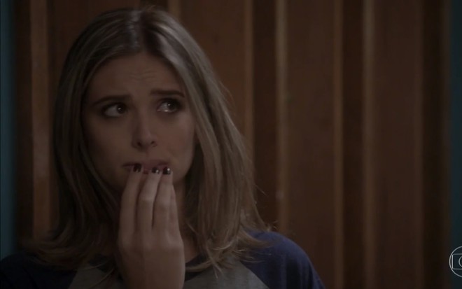 A atriz Juliana Paiva,  com a mão na boca e expressão de arrependida, em cena como Cassandra em Totalmente Demais