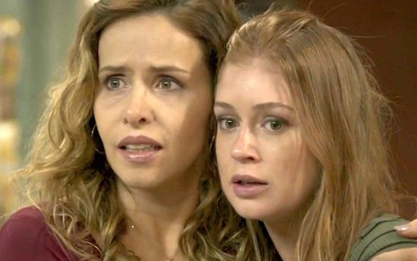 Gilda (Leona Cavalli) e Eliza (Marina Ruy Barbosa) abraçadas com expressão de medo em cena de Totalmente Demais