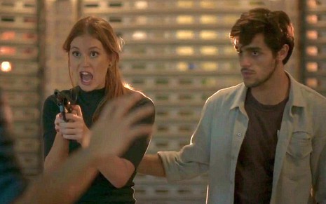 Eliza (Marina Ruy Barbosa) gritando com uma arma na mão em cena de Totalmente Demais
