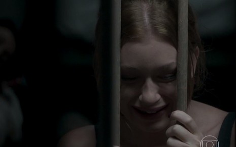 Eliza (Marina Ruy Barbosa) chora com a cabeça encostada nas grades de uma cela em cena de Totalmente Demais