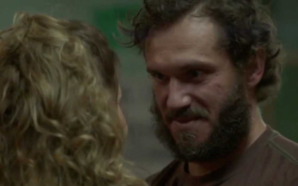 O ator Paulo Rocha com barba e cabelos grandes e desleixados, com expressão mal encarada, caracterizado como o Dino em cena de Totalmente Demais
