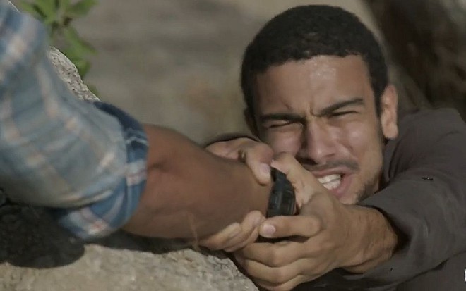 Jacaré (Sergio Malheiros) à beira de um precipício prestes a cair em cena de Totalmente Demais