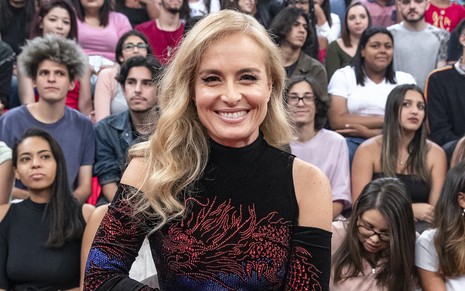 A apresentadora Angélica com uma blusa preta de gola e ombros de fora durante participação no programa Altas Horas