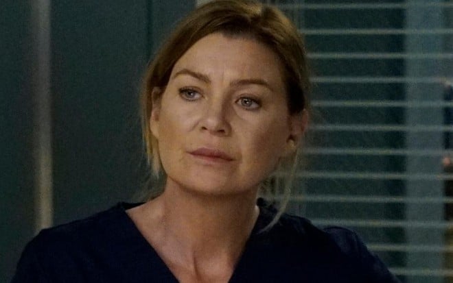 Com uma uniforme azul marinho de médica, Ellen Pompeo fica pensativa em cena da 16ª temporada de Grey's Anatomy