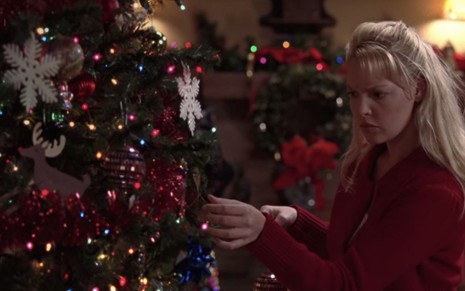 Katherine Heigl como Izzie Stevens em Grey's Anatomy, de roupa vermelha, enfeitando árvore de Natal