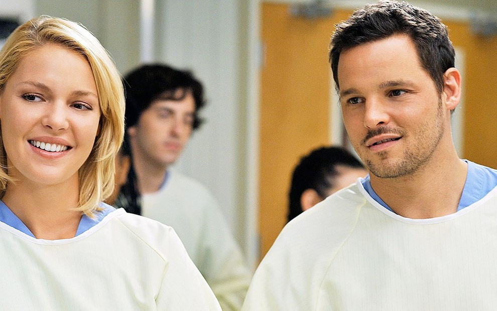 Os atores Katherine Heigl e Justin Chambers com trajes médicos em cena de Grey's Anatomy