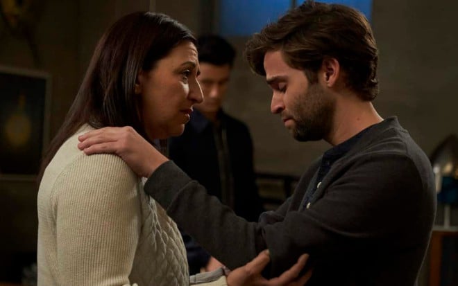 De cabeça baixa, Jake Borelli coloca as mãos no ombro de Michelle Gardner em Grey's Anatomy