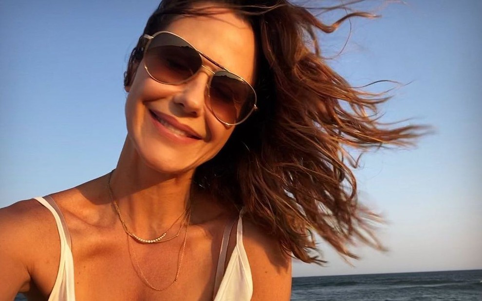 Guilhermina Guinle em selfie postada no Instagram com cabelos ao vento e uma praia ao fundo
