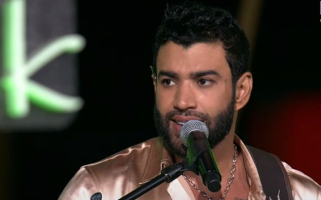 Gusttavo Lima em frente a microfone durante live transmitida pelo YouTube