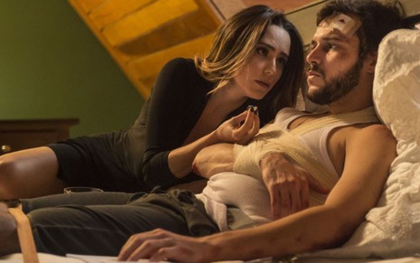 Os atores Fernanda Vasconcellos e Jayme Matarazzo numa cama em cena de Haja Coração, ele com vários curativos de feridas