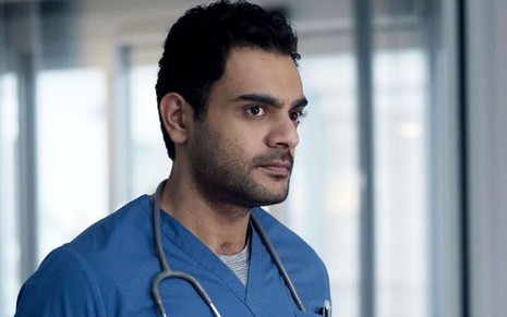 O ator Hamza Haq usa trajes médicos em cena da série Transplant - Uma Nova Vida
