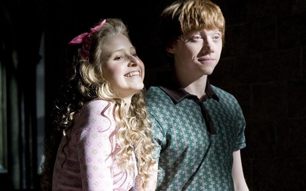Jessie Cave abraça o braço de Rupert Grint em cena de Harry Potter e o Enig...
