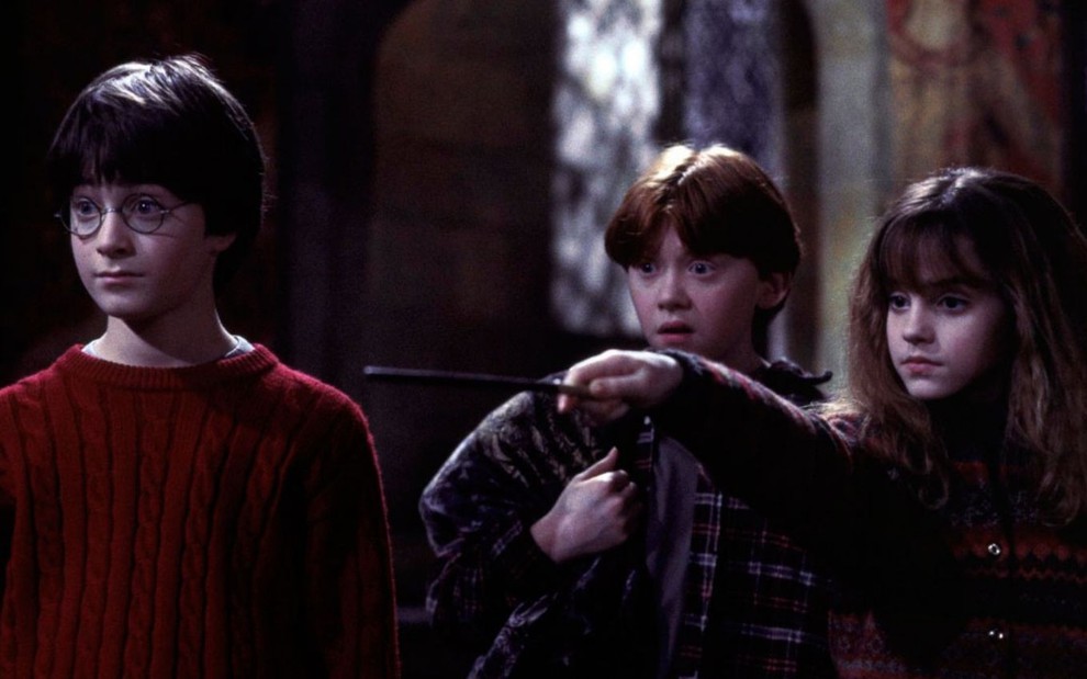 Daniel Radcliffe, Rupert Grint e Emma Watson em cena do filme Harry Potter e a Pedra Filosofal, lançado originalmente em 2001