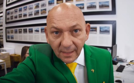 O empresário Luciano Hang em vídeo gravado em uma loja Havan; ele está de terno verde e amarelo