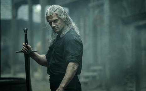 O ator Henry Cavill aparece de lado e caracterizado como o personagem Geralt de Rívia em The Witcher