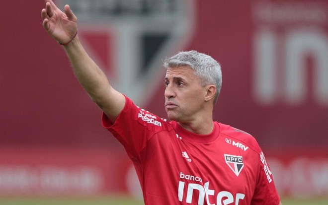 Técnico Hernán Crespo em treino do São Paulo, olhando para o lado com o braço erguido e de vermelho