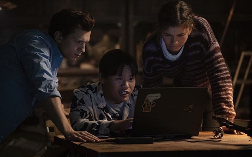 Tom Holland, Jacob Batalon e Zendaya procuram por algo no computador em cena de Homem-Aranha 3