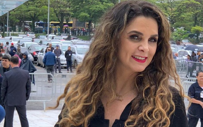Luiza Ambiel, ex-musa da Banheira do Gugu, posa sorridente para foto no velório de Gugu Liberato (1959-2019)