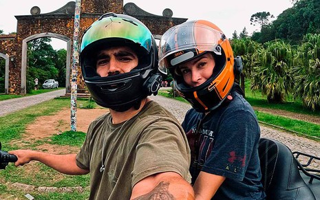 Caio Castro e Grazi Massafera em registro no Instagram: sentados na moto do ator, eles estão de capacete e olham para a câmera