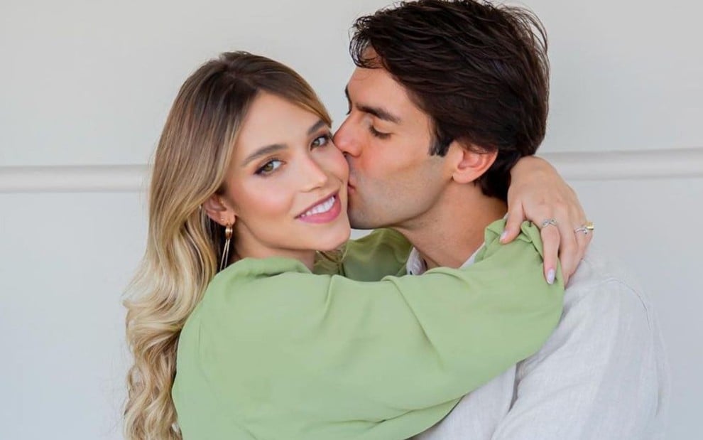 Foto da modelo Carol Dias Leite sendo beijada no rosto pelo marido, o jogador Kaká