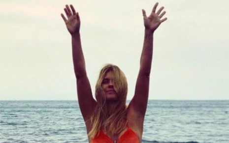 A atriz Carolina Dieckmann em foto publicada no Instagram em que aparece de biquíni e com os braços levantados